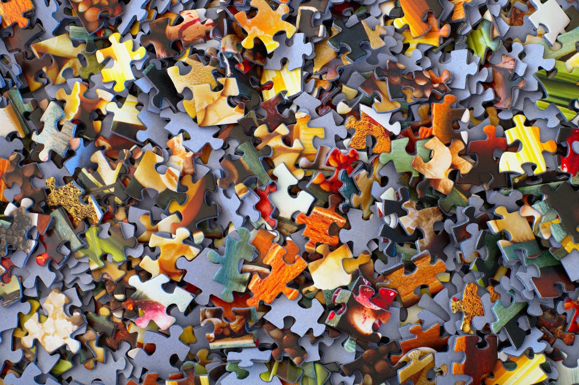 Bunte, verstreute Puzzlestücke in verschiedenen Farben und Formen.